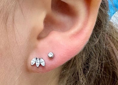 Close-up of elegant ear piercing with sparkling jewelry at ER Laser Clinic, Wisbech, England, GB.