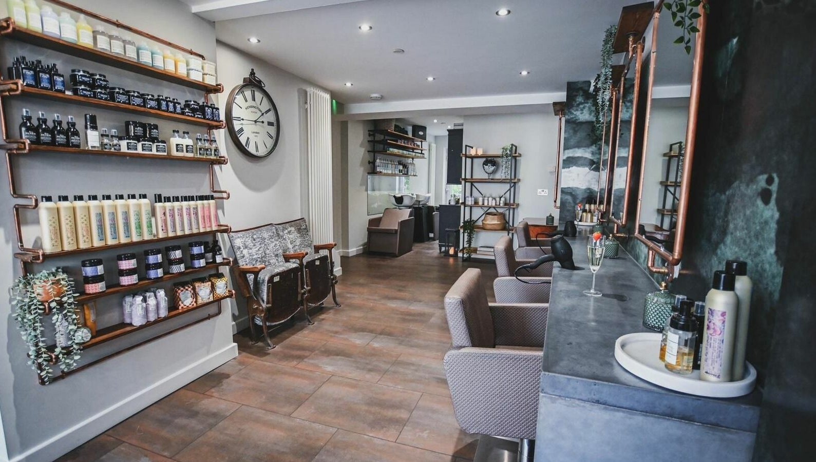 Modern interior of Oliver's Hair Studio Limited, Belper, England, GB, featuring stylish chairs and beauty products.