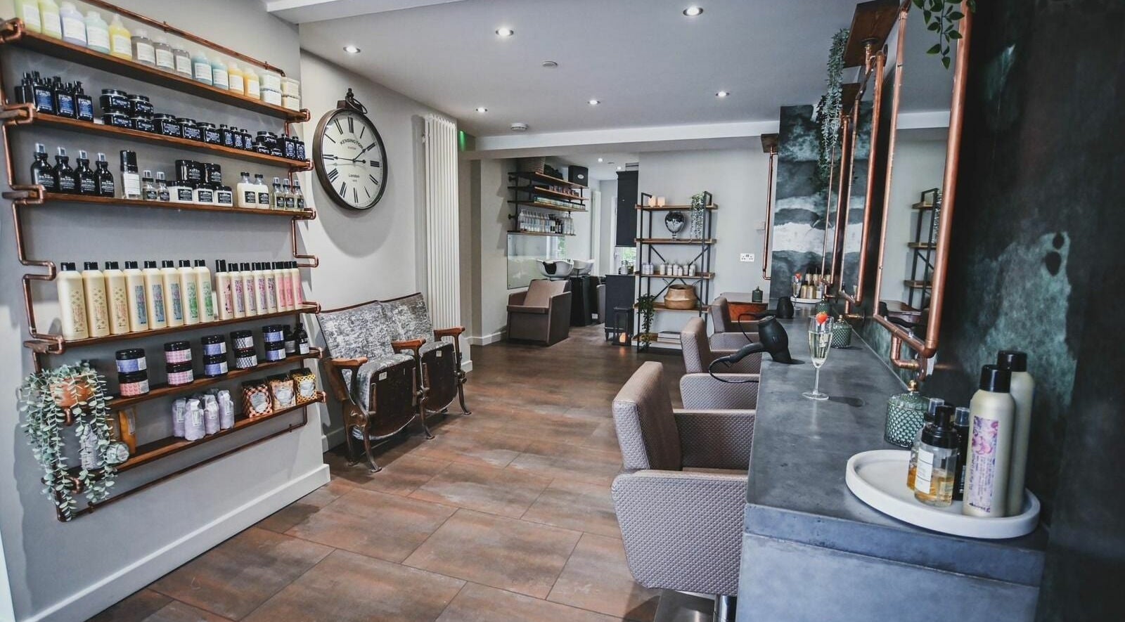 Modern interior of Oliver's Hair Studio Limited, Belper, England, GB, featuring stylish chairs and beauty products.