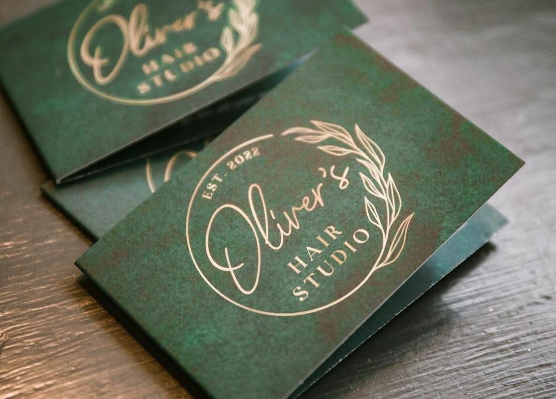 Close-up of cards from Oliver's Hair Studio Limited in Belper, England, showcasing elegant design.
