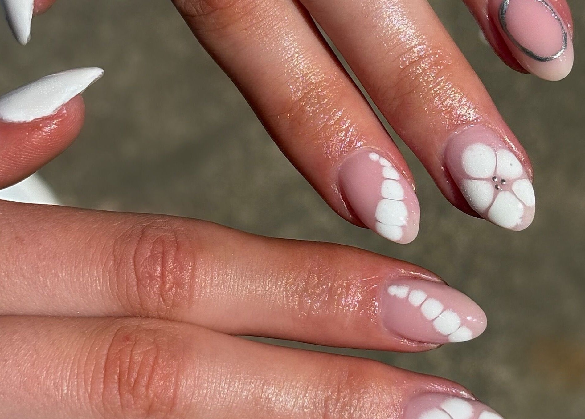 Elegant nail art with white floral design at Darc’s Beauty, Frampton Cotterell, England, GB.