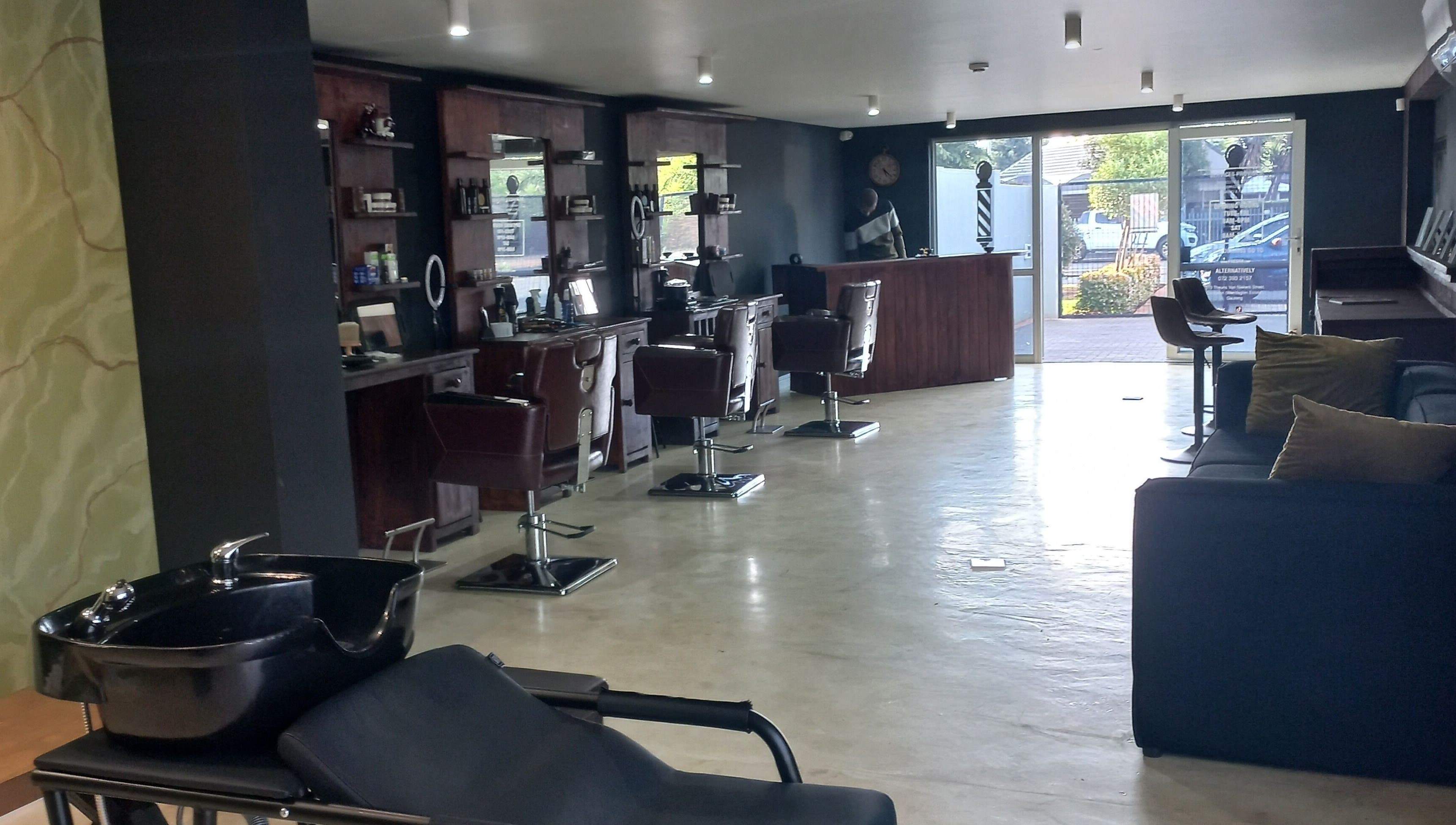 Modern and stylish interior of Maine Barber in Centurion, Gauteng, ZA with sleek chairs and mirrors.