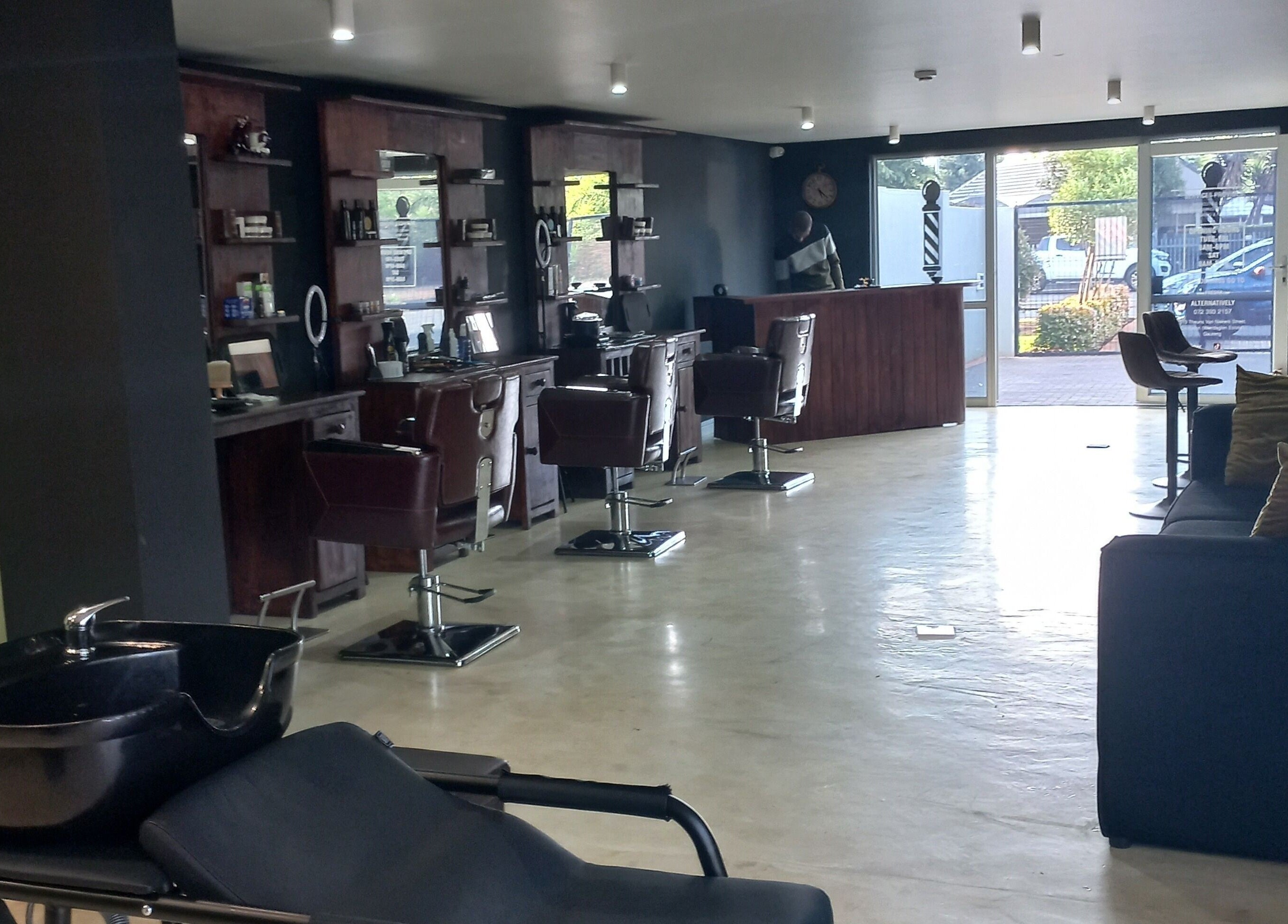 Modern and stylish interior of Maine Barber in Centurion, Gauteng, ZA with sleek chairs and mirrors.