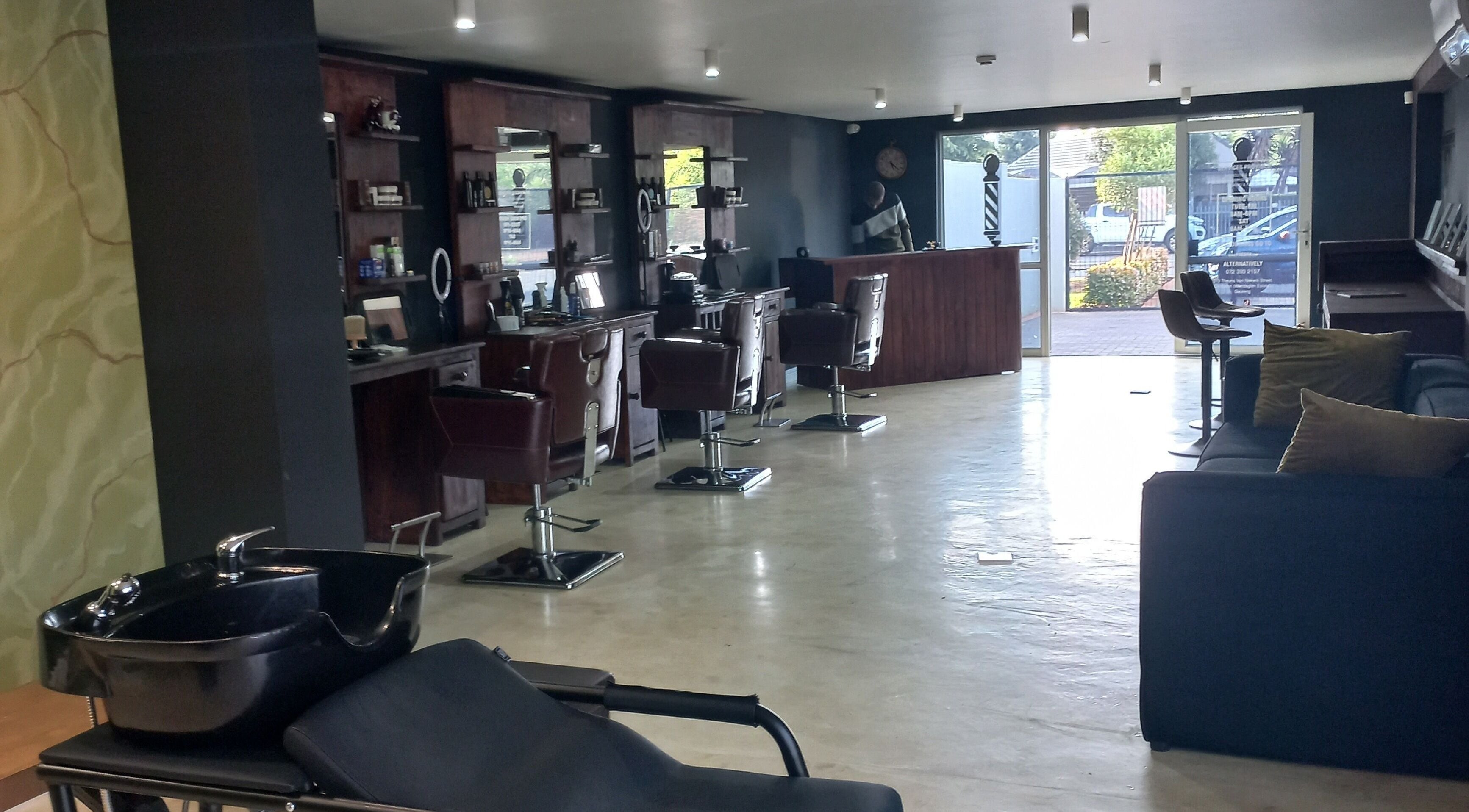 Modern and stylish interior of Maine Barber in Centurion, Gauteng, ZA with sleek chairs and mirrors.