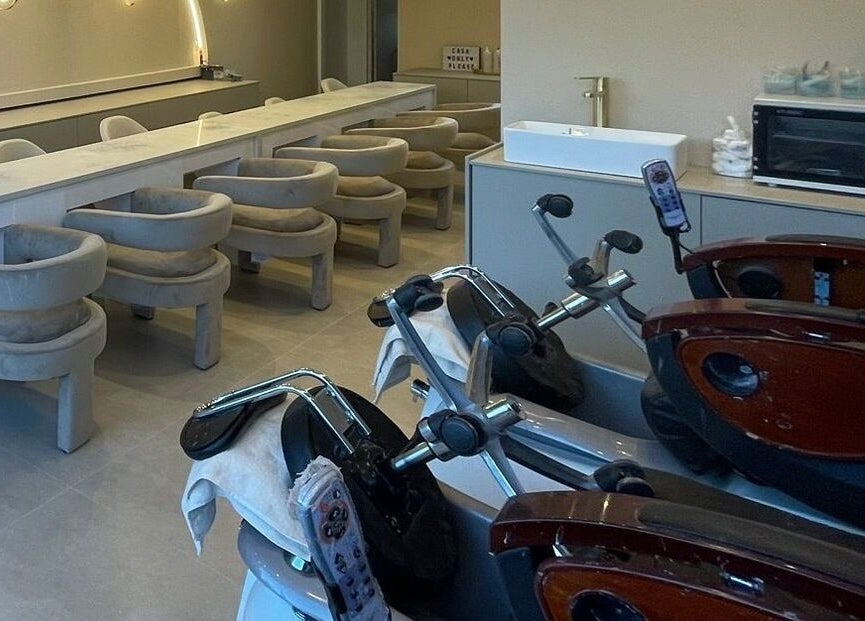 Elegant interior of Prim and Polished salon in Bexleyheath, England, featuring modern salon chairs and amenities.