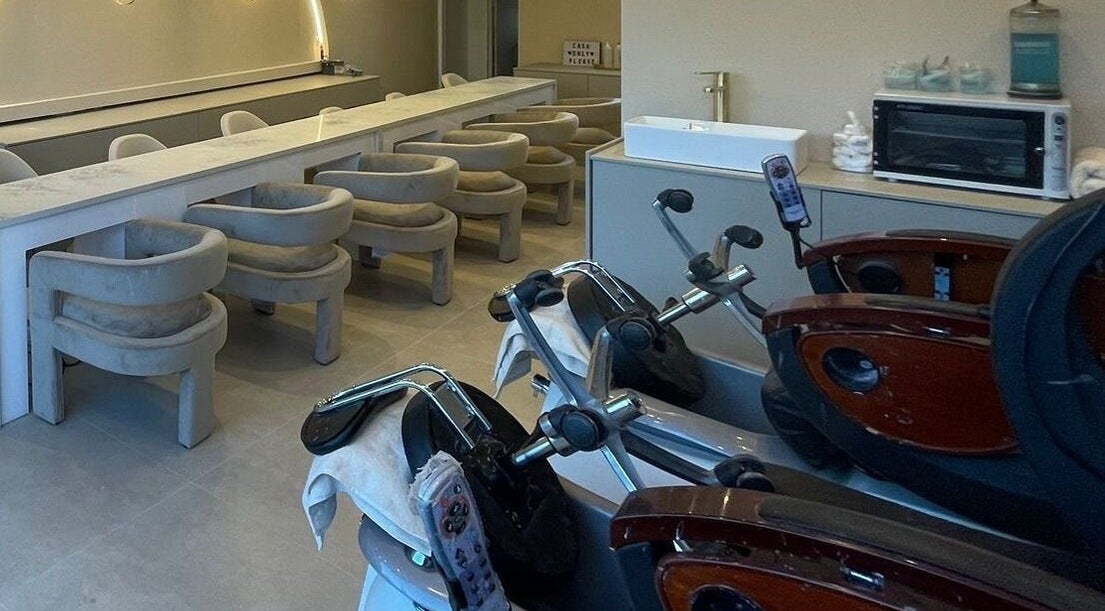 Elegant interior of Prim and Polished salon in Bexleyheath, England, featuring modern salon chairs and amenities.