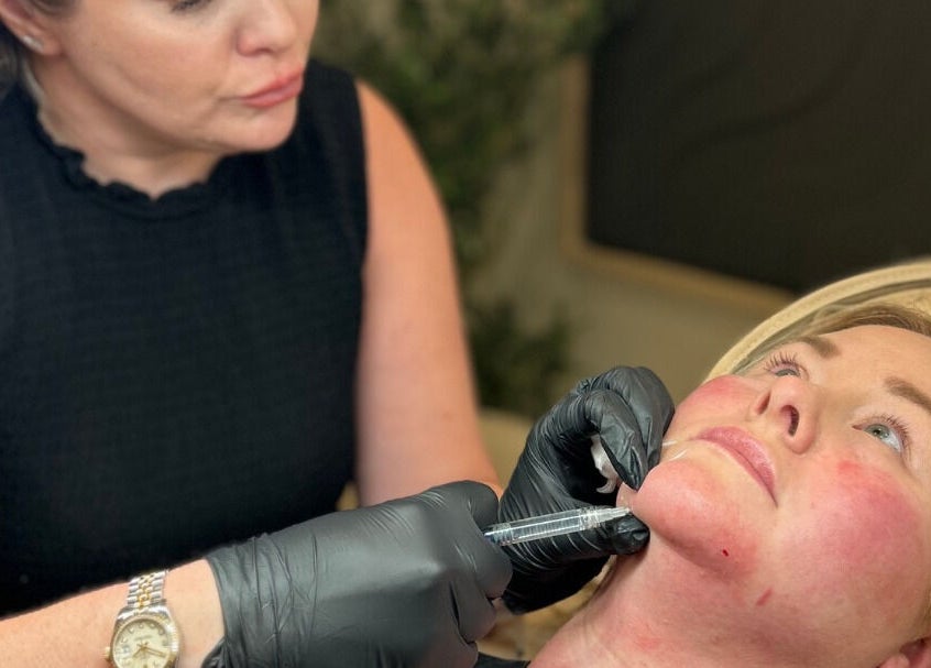 Skilled aesthetician at Impeccable Aesthetics Warrington, England, GB performing facial treatment.