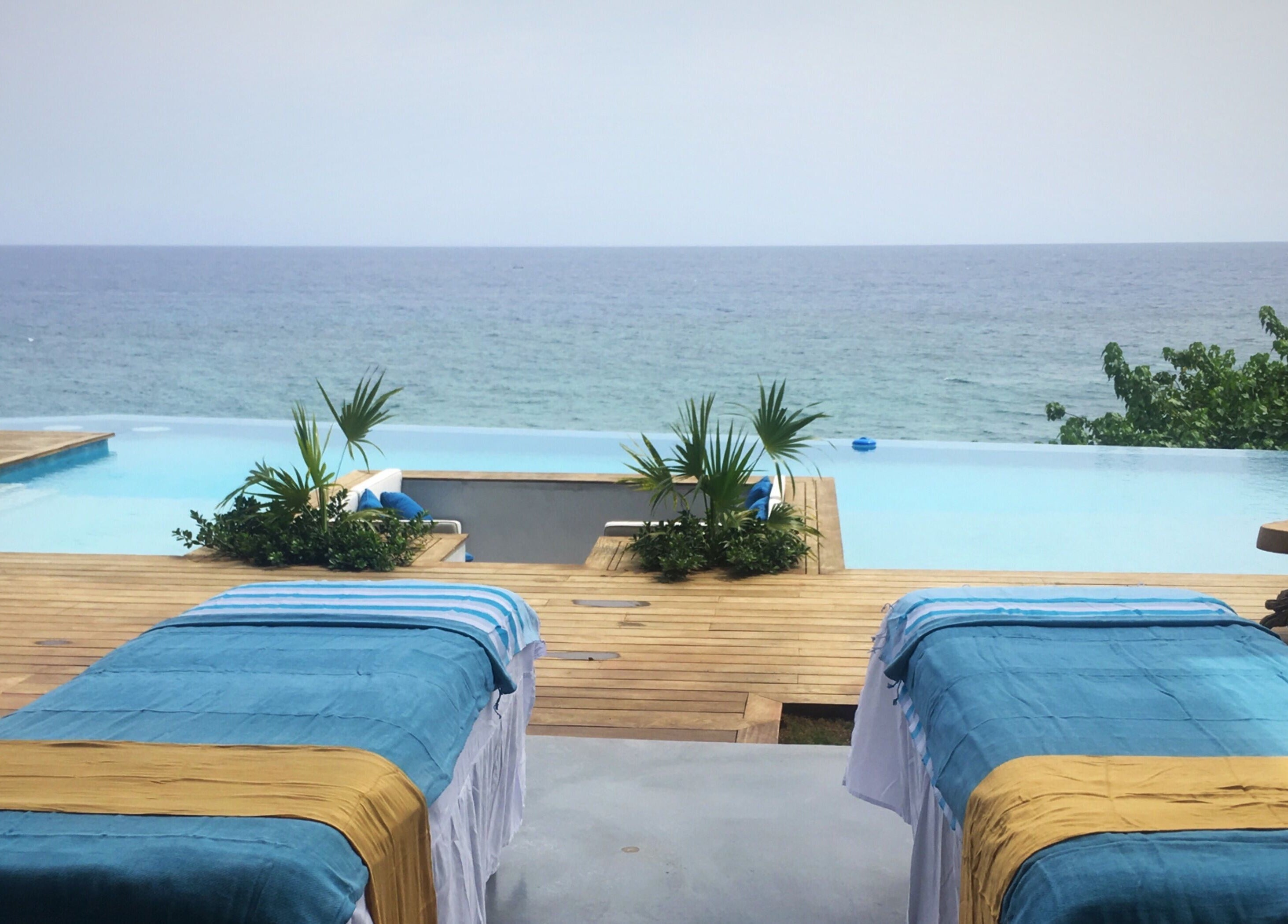Relaxing massage tables overlooking the ocean at Ocean Serenity Relaxing Massages across Jamaica, JM.