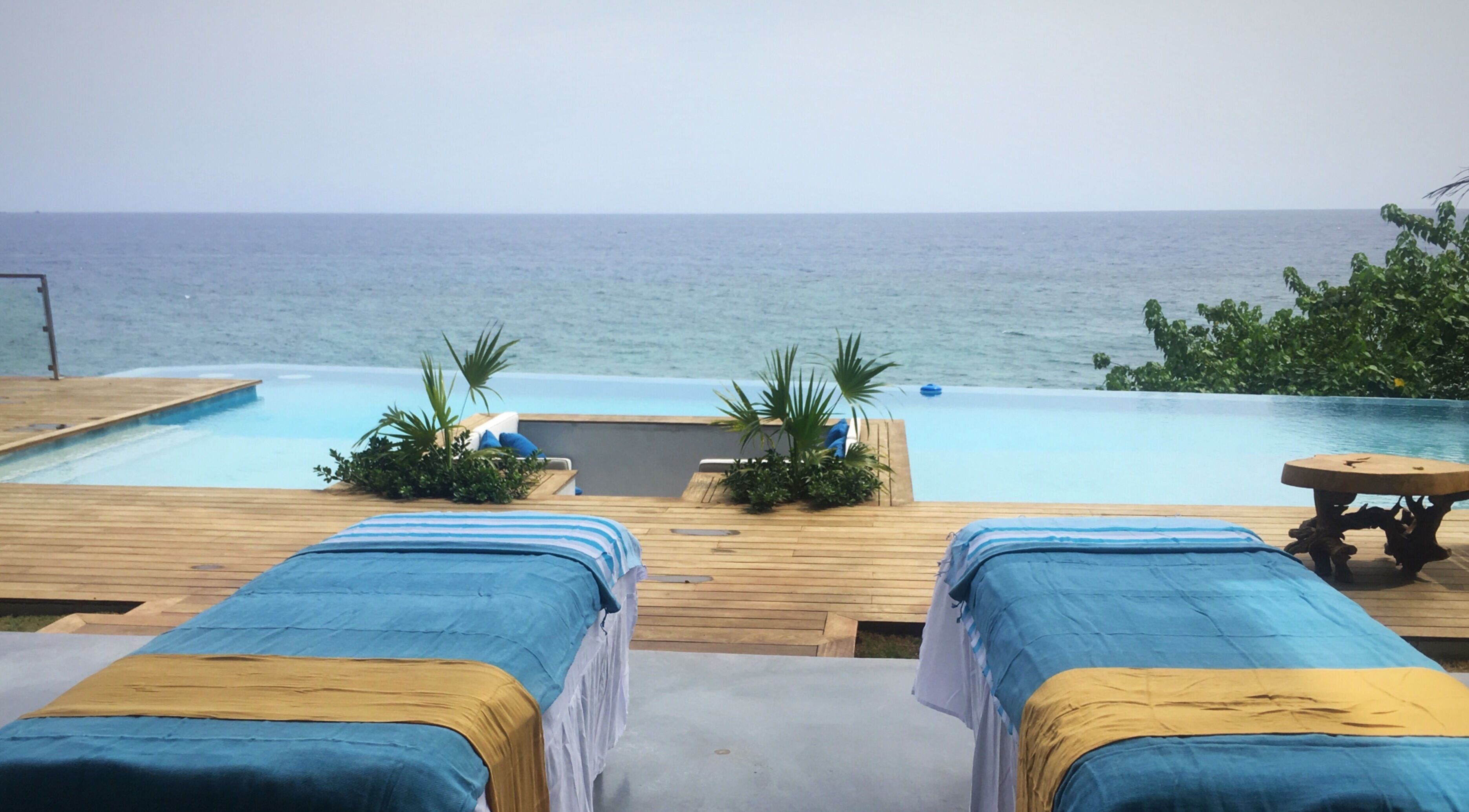 Relaxing massage tables overlooking the ocean at Ocean Serenity Relaxing Massages across Jamaica, JM.