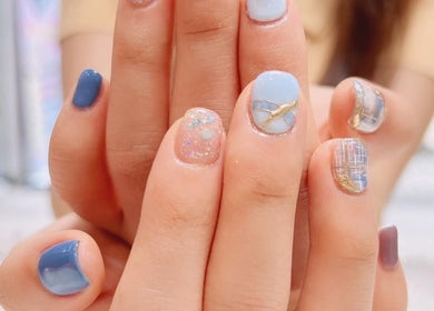 Stylish nail design at Joyi Beauty, 新加坡, SG, featuring blue and gold accents with glitter.
