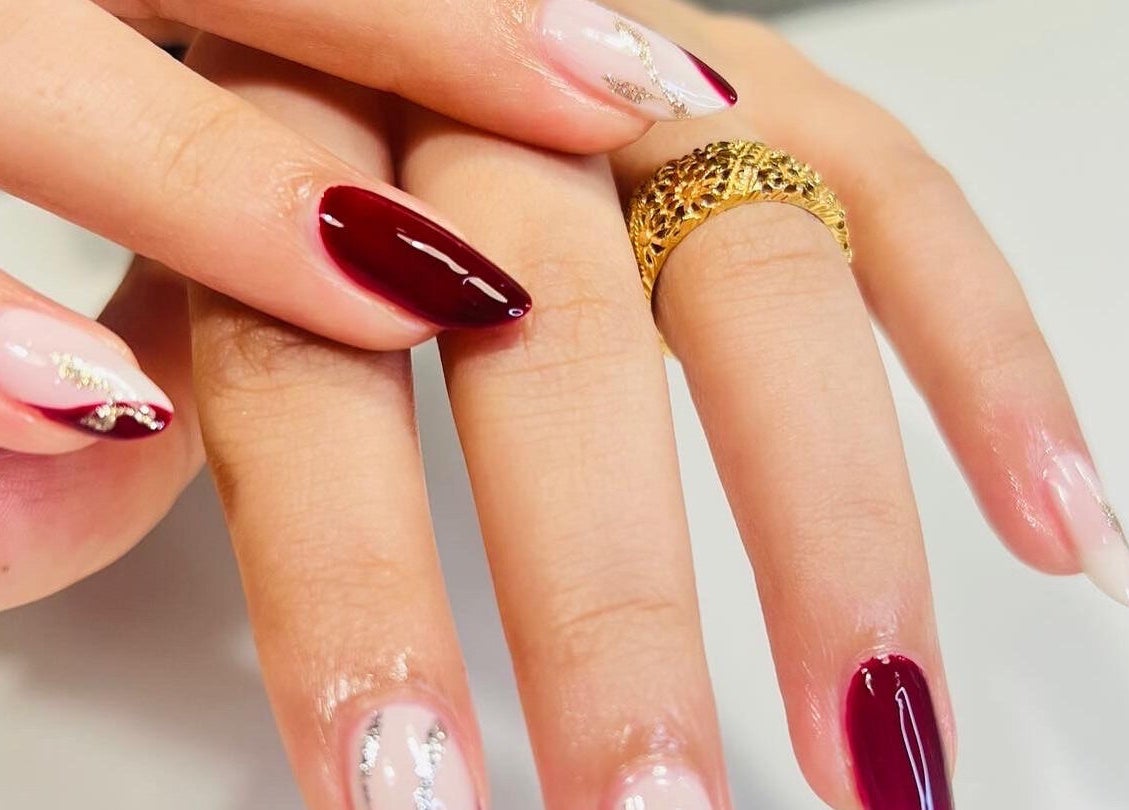 Luxurious nail art at Luxury Spa, Al Qatif, Eastern Province, SA featuring rich maroon and delicate designs.