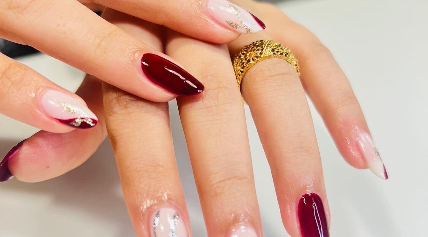 Luxurious nail art at Luxury Spa, Al Qatif, Eastern Province, SA featuring rich maroon and delicate designs.