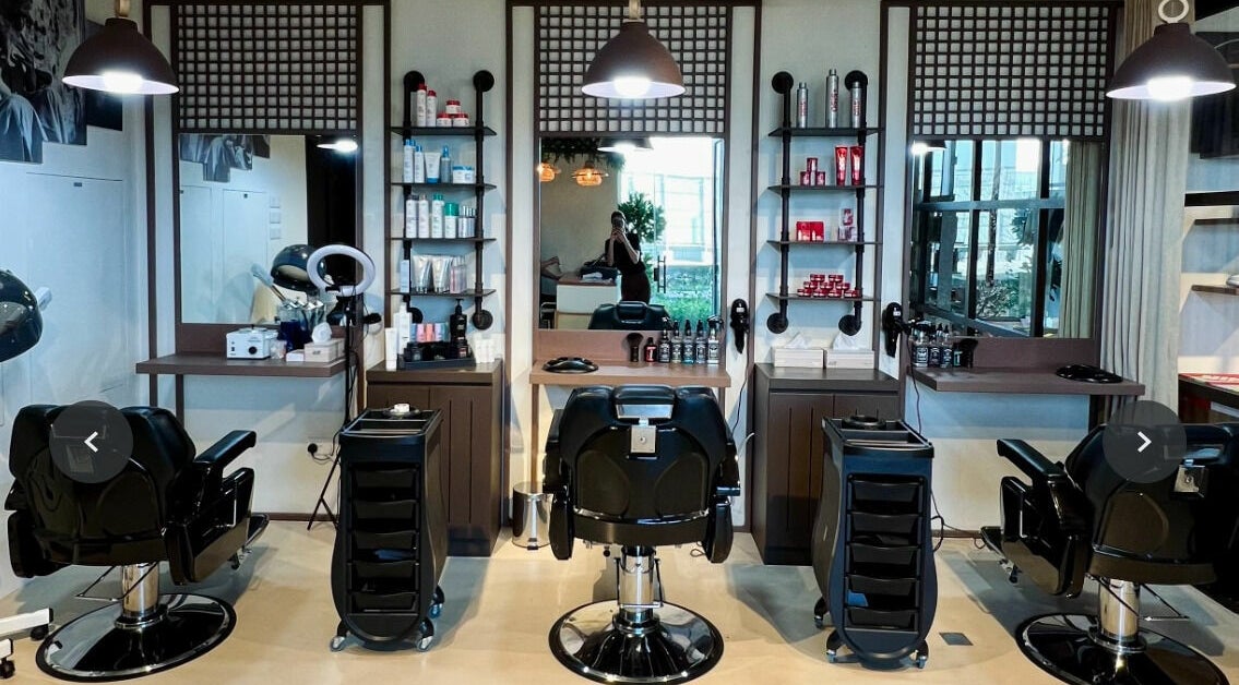 Modern interior of AMAZI Café & Barbershop in Dubai, AE featuring sleek barber chairs and product shelves.