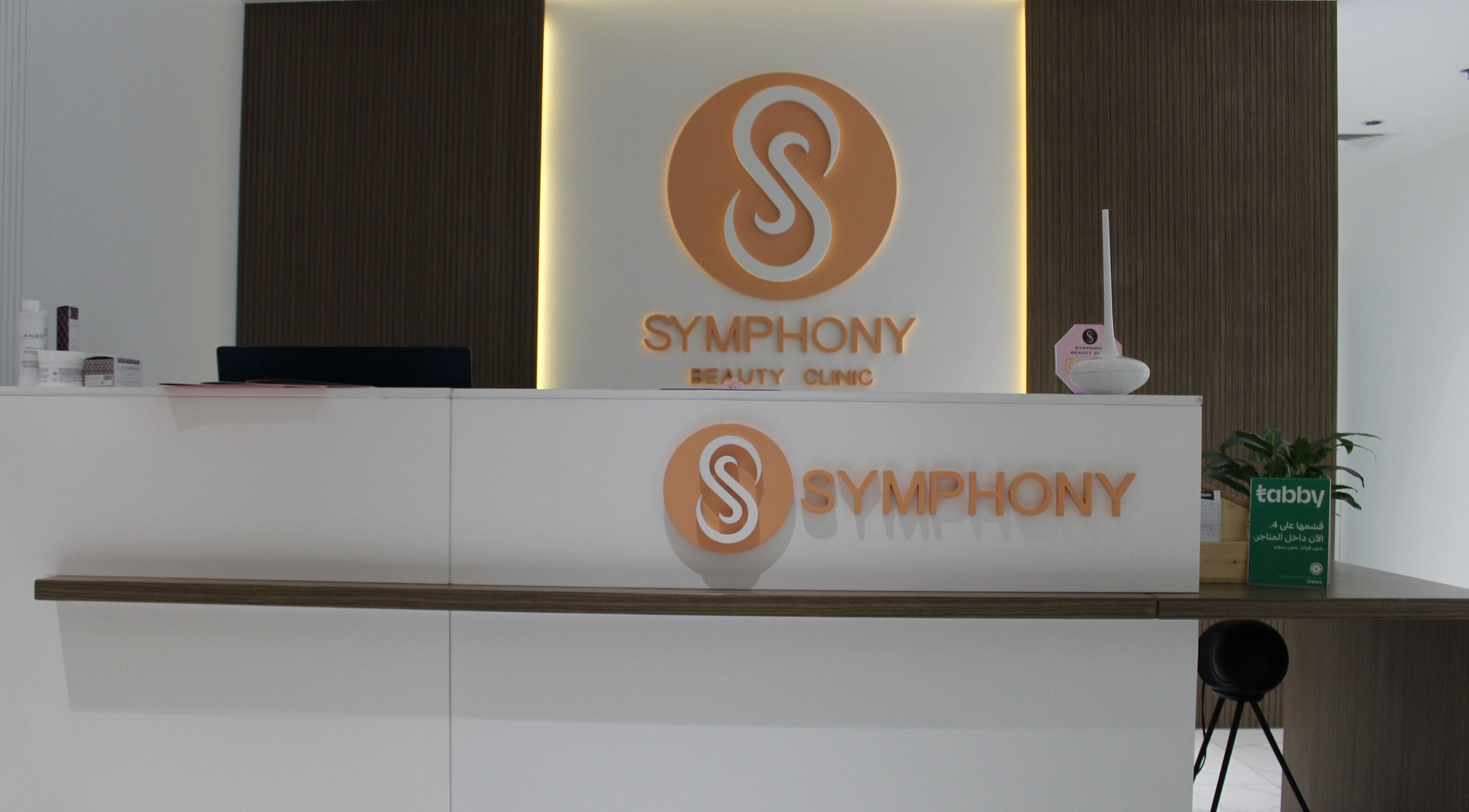 Reception desk at Symphony Clinic in Dubai, AE, featuring the logo and modern design elements.