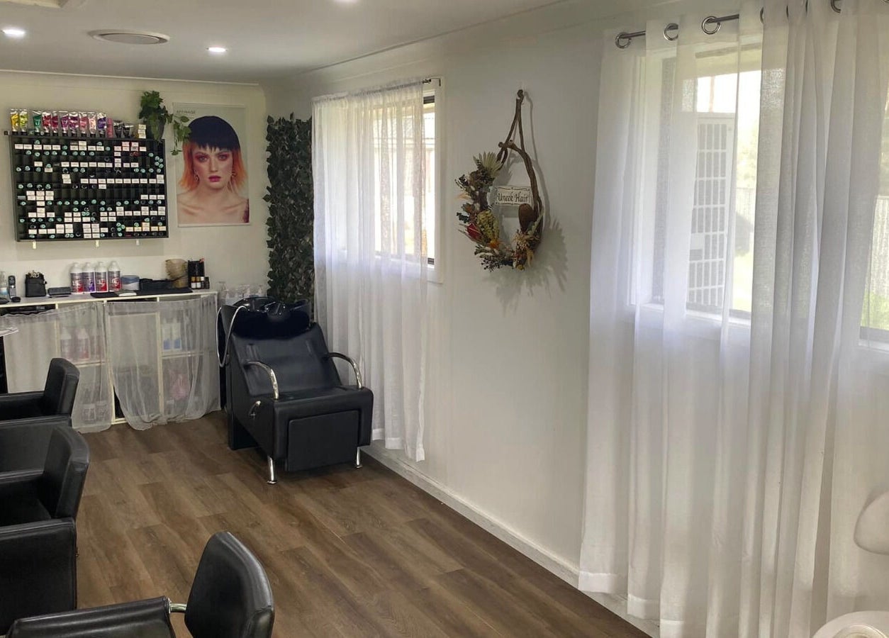 Inviting interior of Uneek Hair, Tanilba Bay, New South Wales, AU with modern chairs and styling products.