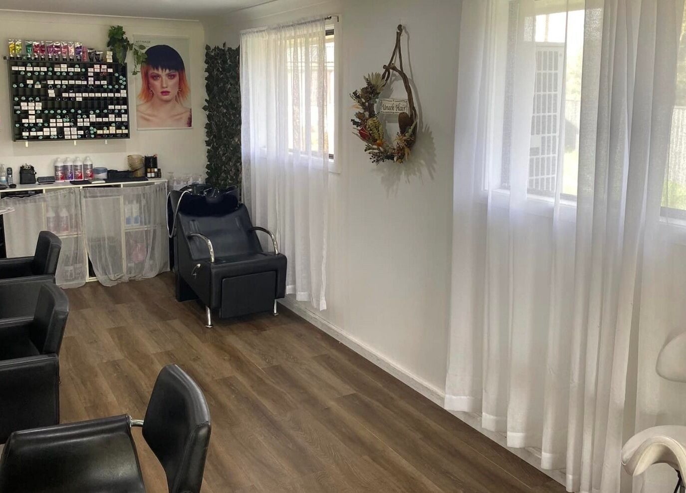 Modern salon interior at Uneek Hair in Tanilba Bay, New South Wales, AU, featuring stylish chairs and hair products.