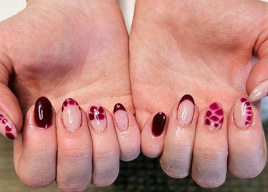 Elegant crimson nail art at Whisk Beauty, Blenheim, Marlborough, NZ, showcasing intricate designs and glossy finish.