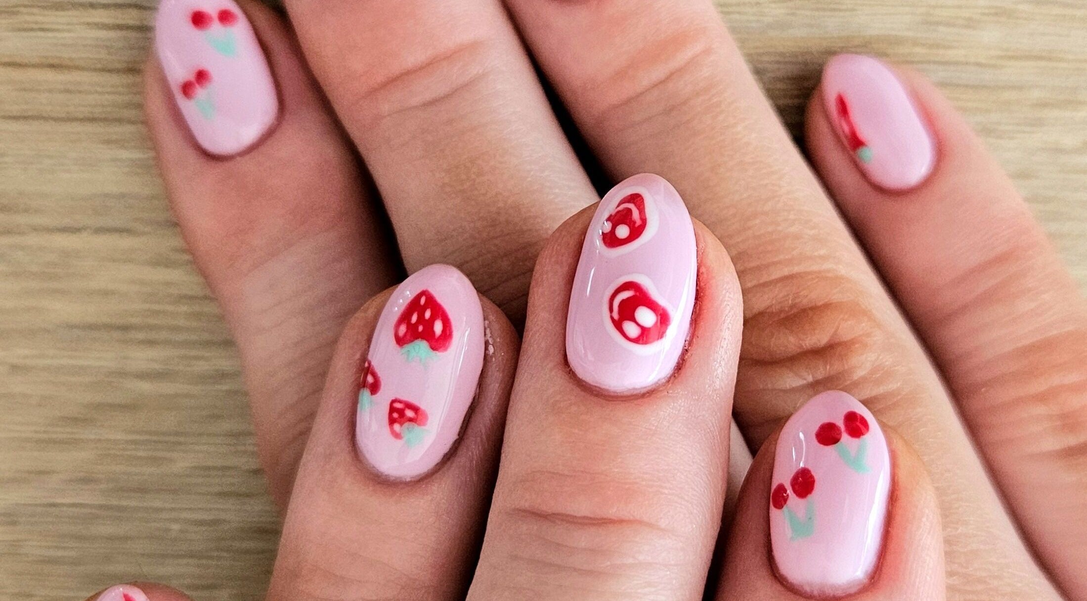 Stylish pink nails with cherry and strawberry art at Whisk Beauty, Blenheim, Marlborough, NZ.