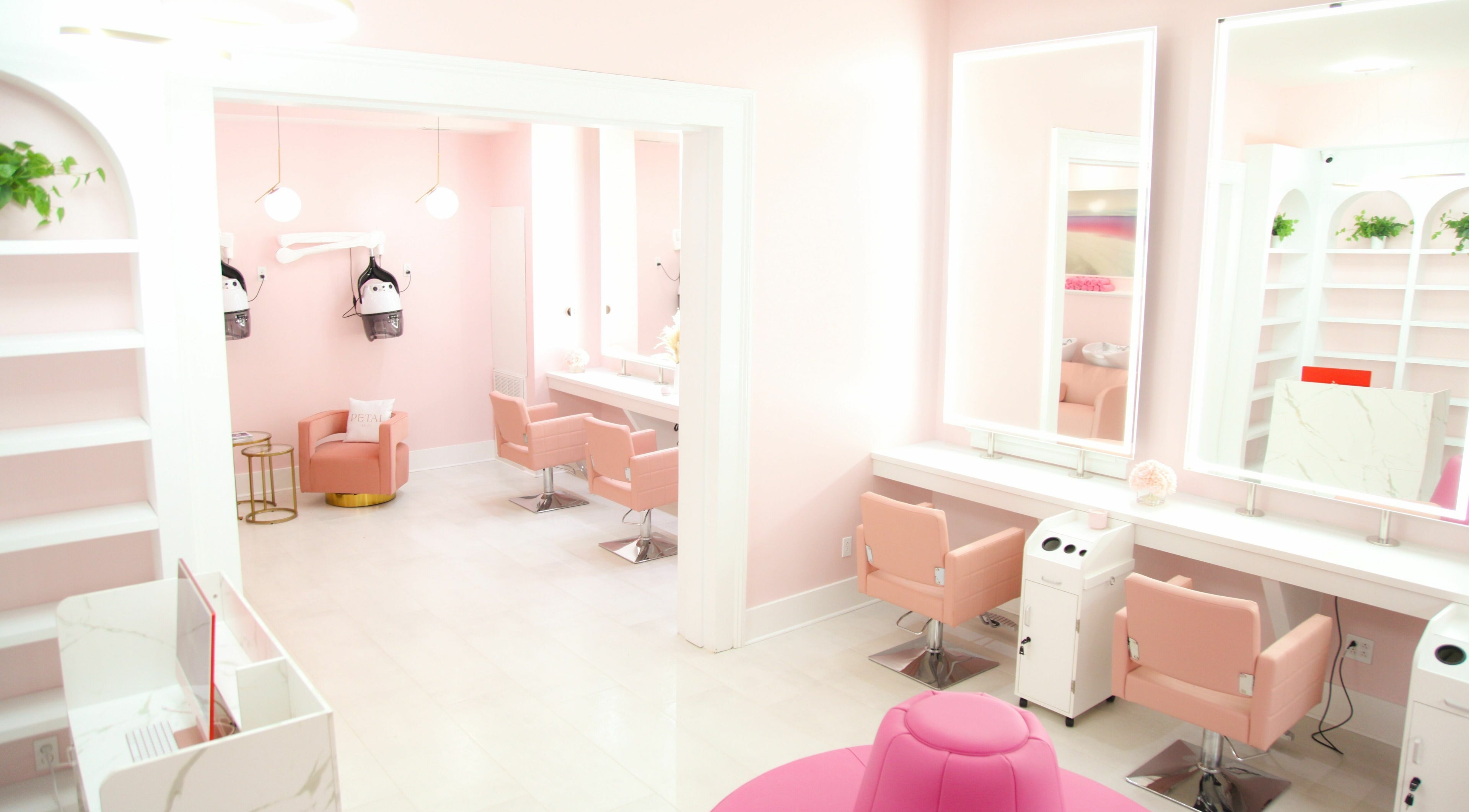 Stylish interior of Petal Salon in New Orleans, Louisiana, US featuring modern pink decor and salon chairs.