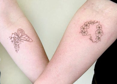 Floral tattoos on arms at Thi Aim, Richmond, South Australia, AU, showcasing delicate linework.