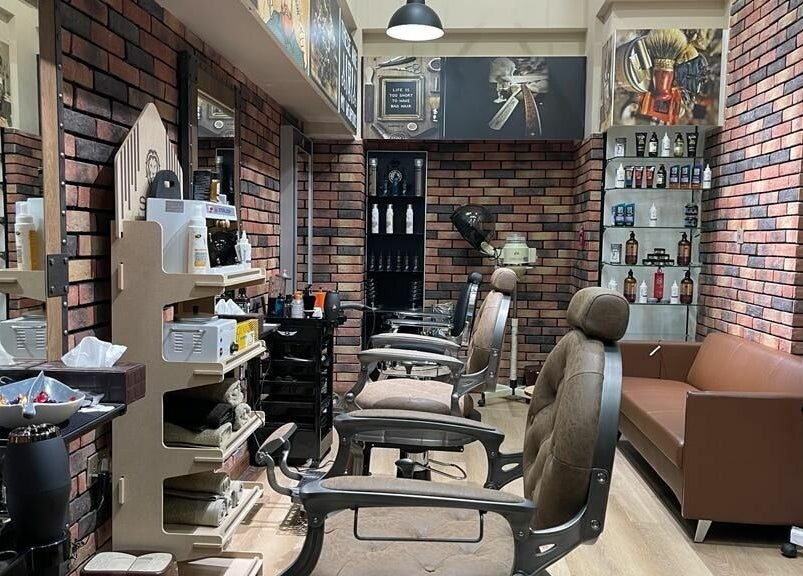 Interior of Gentsy Barber Shop in Dubai, AE showcasing elegant chairs and organized grooming products.