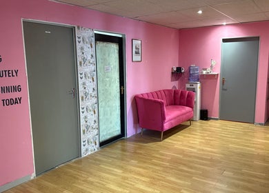 Stylish pink reception area at Niceglamebynicole, Randburg, ZA, with plush sofa and motivational wall text.