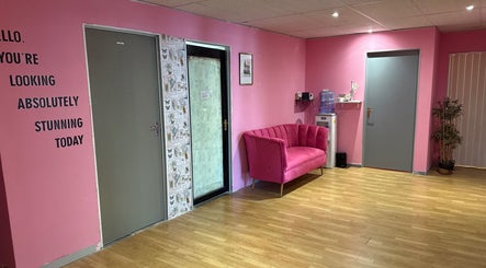 Stylish pink reception area at Niceglamebynicole, Randburg, ZA, with plush sofa and motivational wall text.