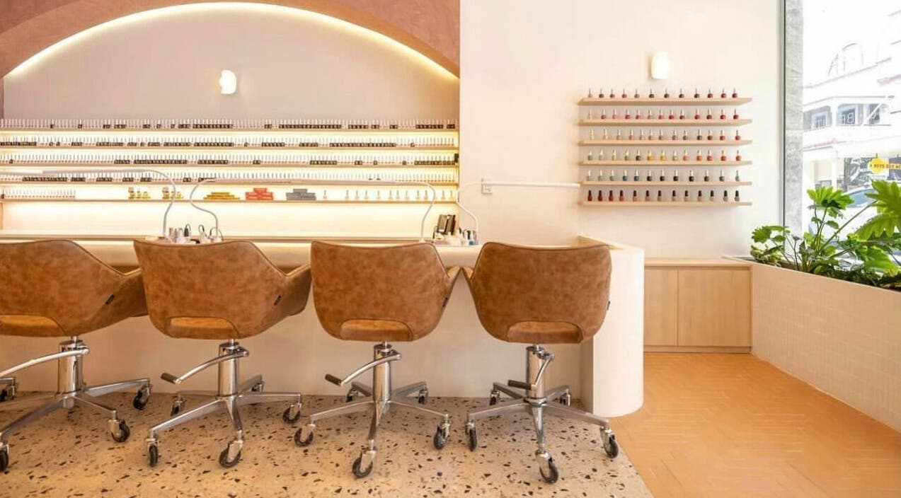 Modern nail salon at Blushing on Hunter, Newcastle, New South Wales, AU showcasing sleek chairs and nail polish wall.