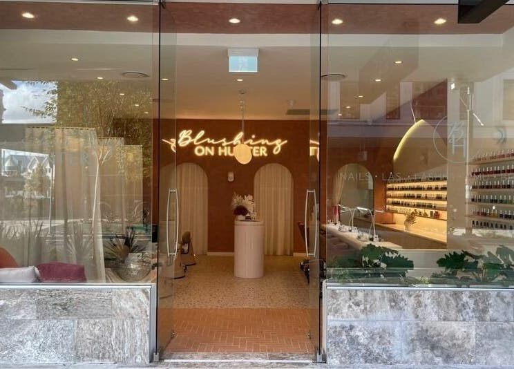 Front view of Blushing on Hunter in Newcastle, New South Wales, AU with stylish interiors and nail polish display.