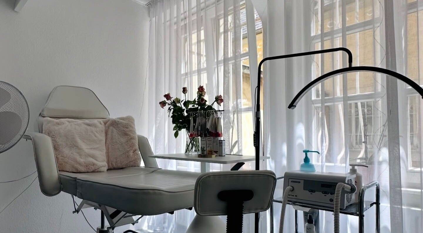 Chaise de soin élégante chez Vilar and K Sàrl, Luxembourg, Luxembourg, LU, avec rideaux translucides et roses.