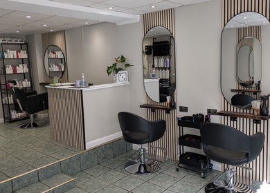 Modern salon seating at Hair Necessities, Newton Abbot, United Kingdom with stylish decor and beauty products.