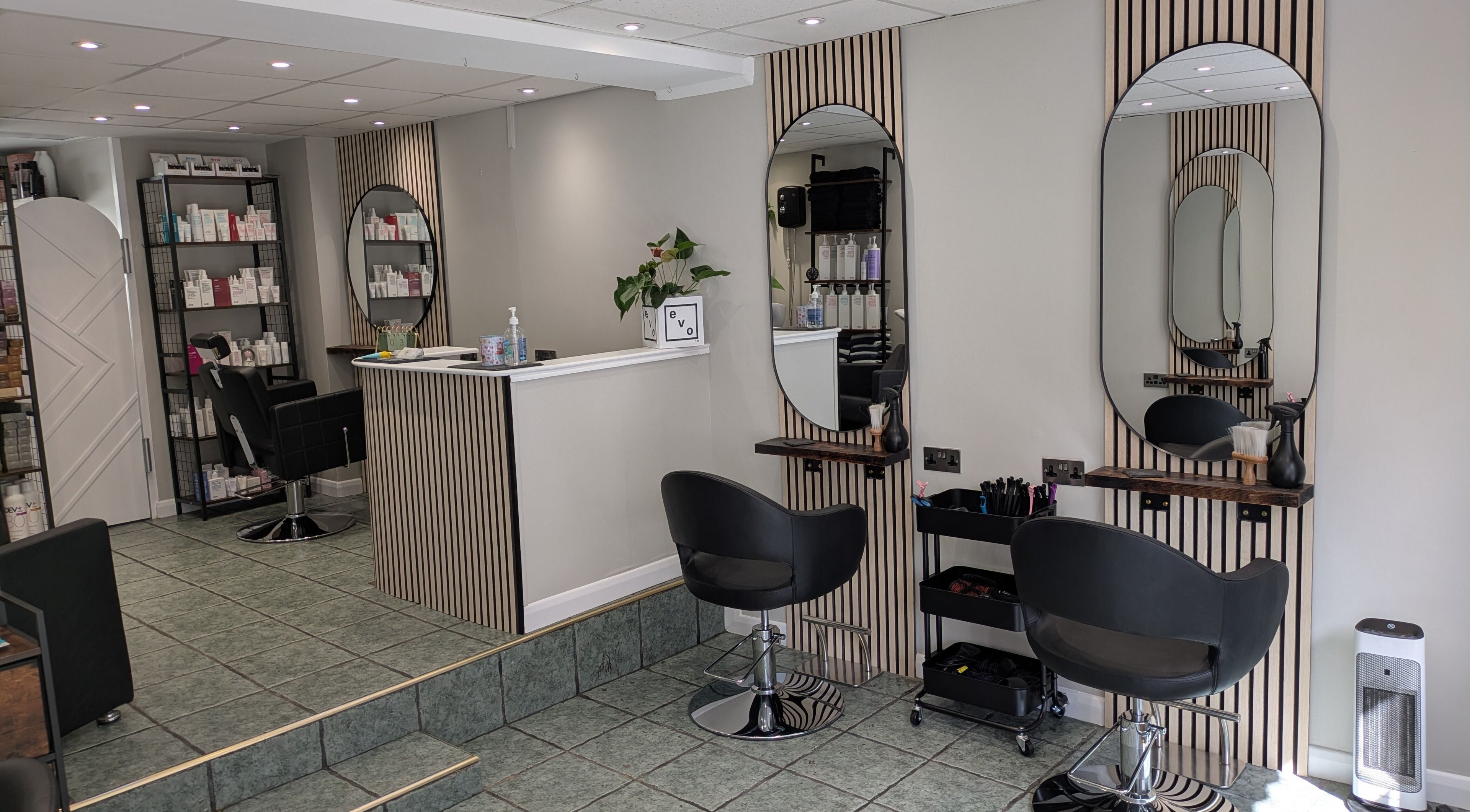 Modern salon seating at Hair Necessities, Newton Abbot, United Kingdom with stylish decor and beauty products.