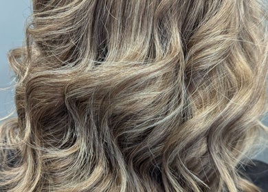 Blonde wavy hair styled elegantly at Hair Necessities in Newton Abbot, United Kingdom, GB.