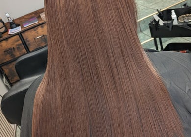 Smooth, straightened hair in salon setting at Hair Necessities, Newton Abbot, United Kingdom, GB.