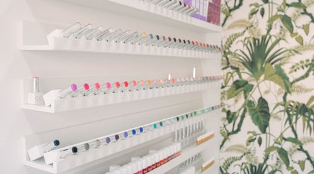 Colorful nail polish display at Wild Beauty, London, England, GB with tropical wall design.