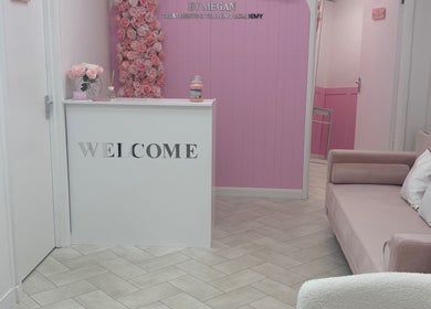 Chic reception with pink decor at House of Angels, St Albans, England, GB. Cozy couch next to welcome desk.