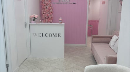 Chic reception with pink decor at House of Angels, St Albans, England, GB. Cozy couch next to welcome desk.
