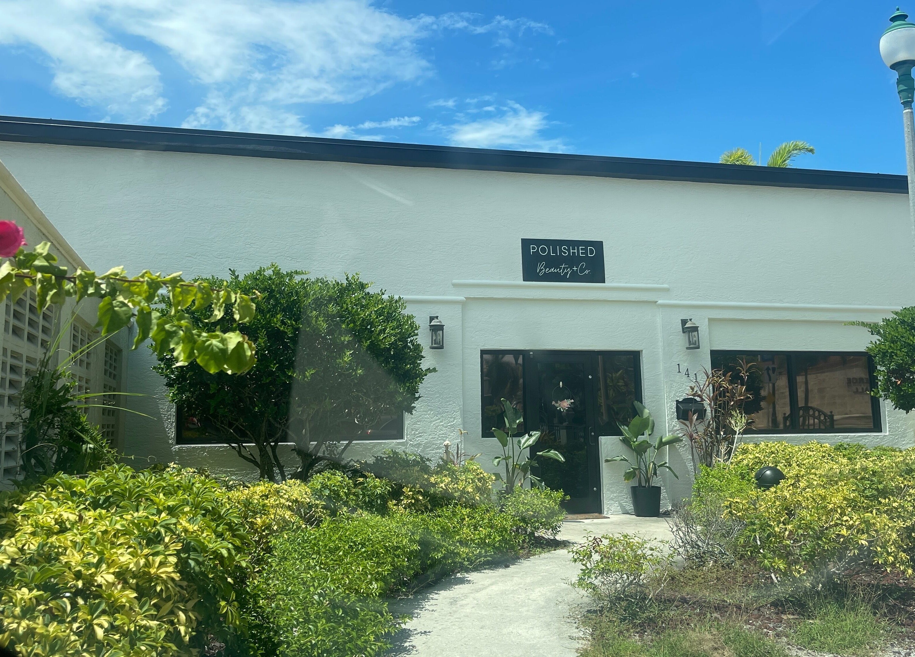 Exterior of Highs & Lows Hair Studio in Fort Pierce, Florida, US surrounded by lush greenery.