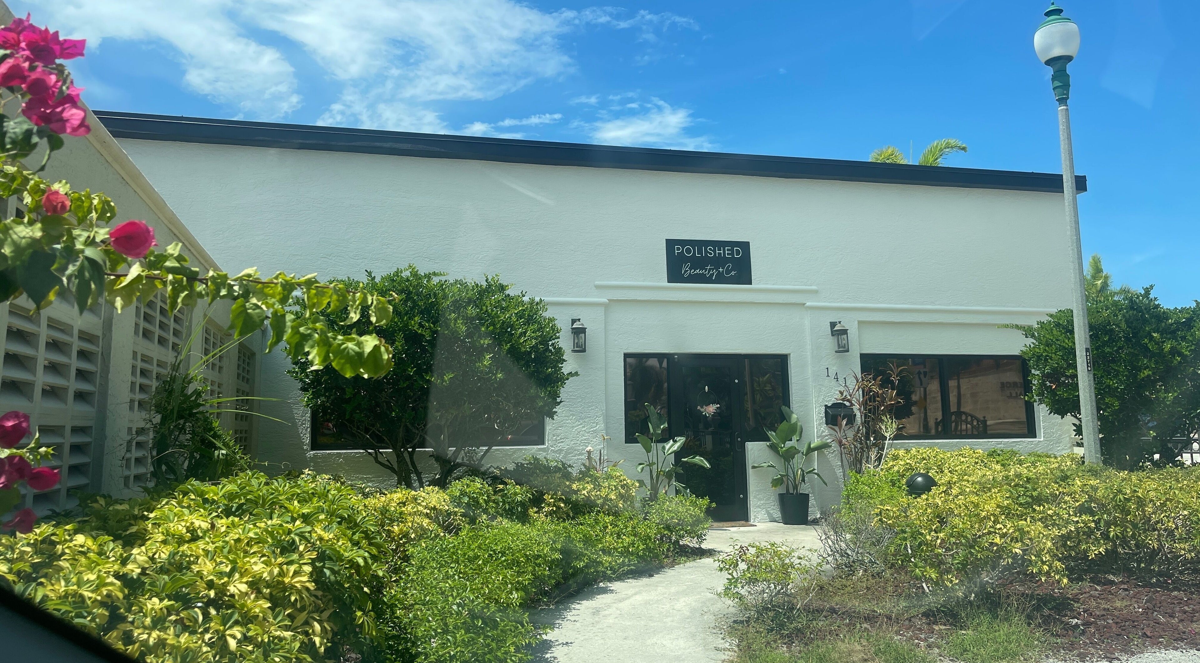 Exterior of Highs & Lows Hair Studio in Fort Pierce, Florida, US surrounded by lush greenery.