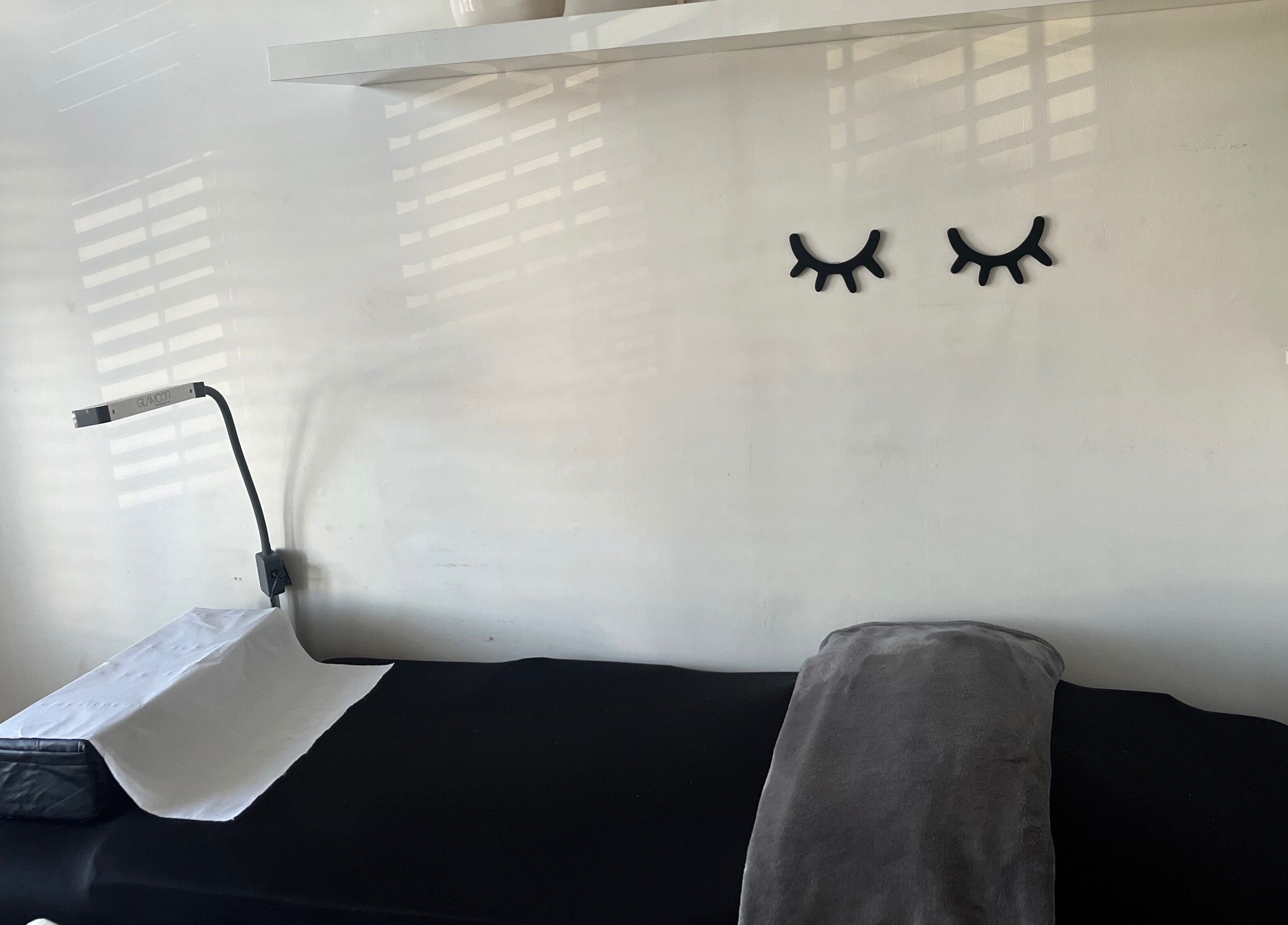 Treatment room at Lash Lovin’, London, England, GB, featuring cozy bed and modern decor.