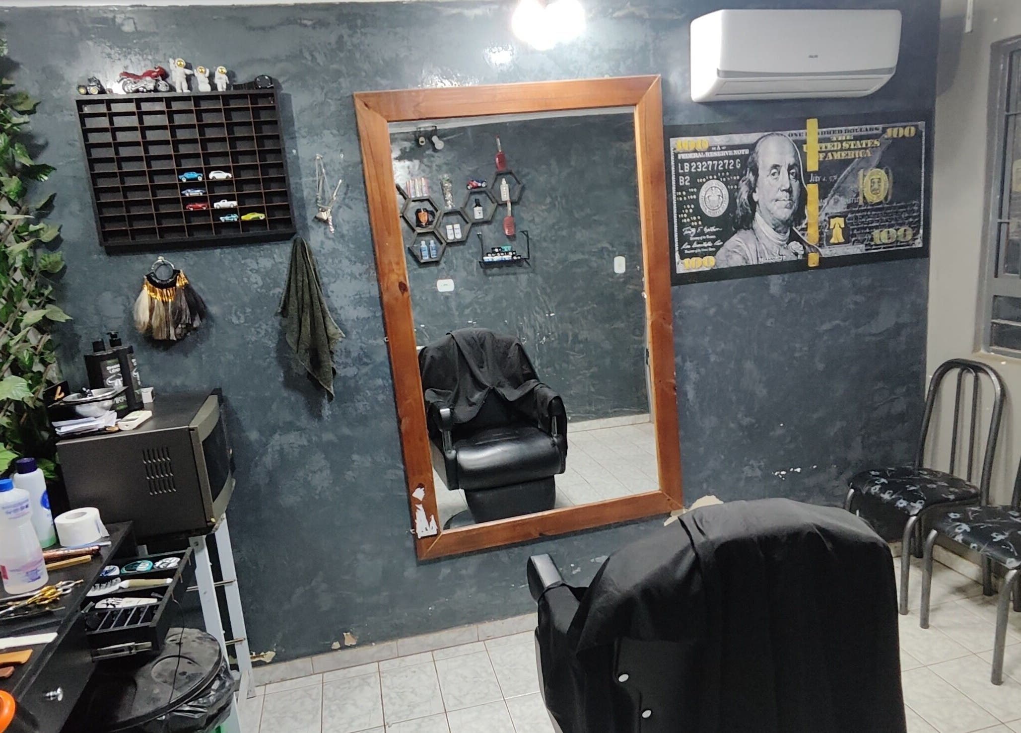 Interior clássico de El Patron Barbearia Clássica, em Paraná, Paraná, BR, com espelho grande e cadeira.