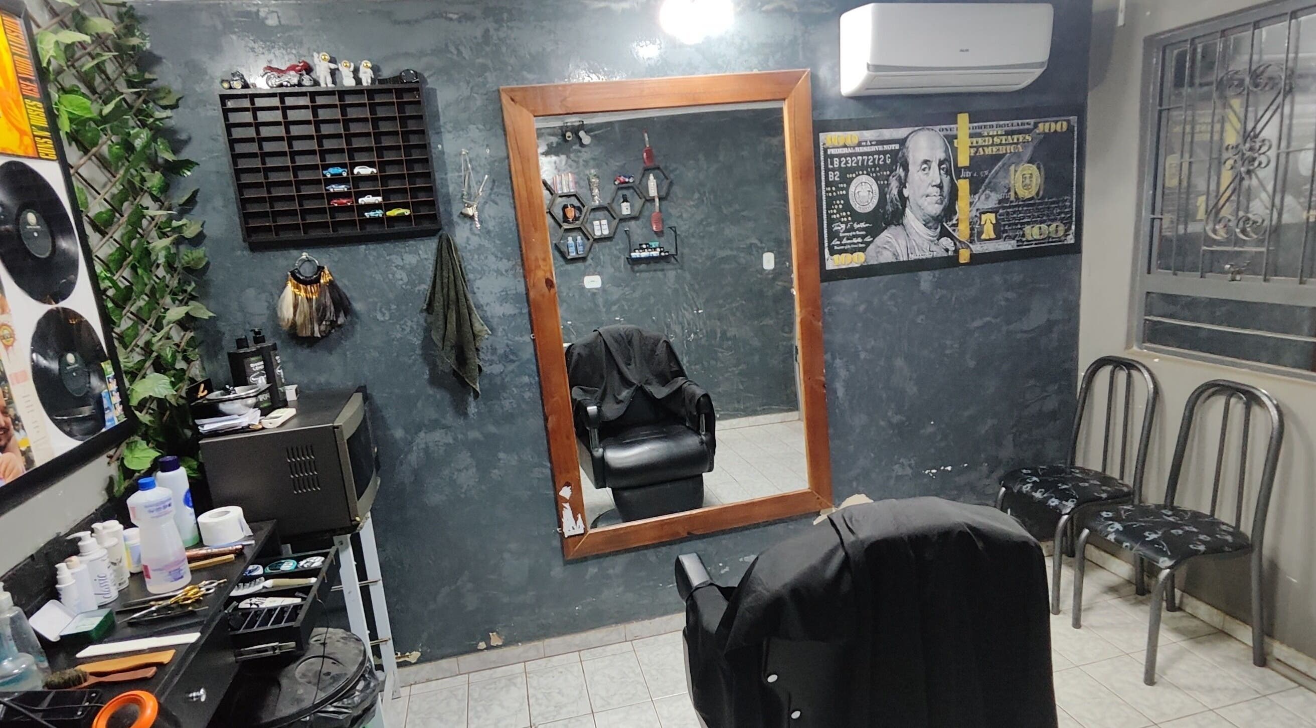 Interior clássico de El Patron Barbearia Clássica, em Paraná, Paraná, BR, com espelho grande e cadeira.