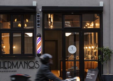 Front of Hermanos Barbershop Loop Street, Cape Town, Western Cape, ZA with stylish lights and decor.