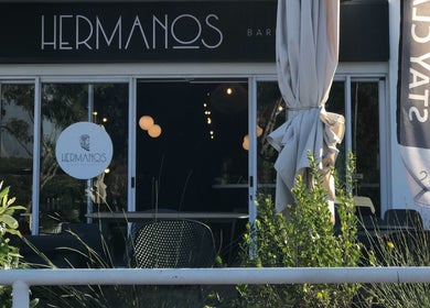 Entrance of Hermanos Barbershop Green Point, Cape Town, Western Cape, ZA, showcasing modern design and greenery.