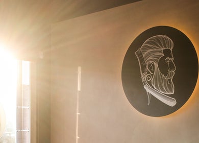 Sunlit interior with logo at Hermanos Barbershop Green Point, Cape Town, Western Cape, ZA.