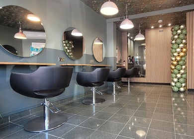 Modern salon interior at Carly at Artistic Hair Co. in Bristol, England, GB with stylish chairs and lighting.