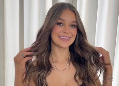 Woman with styled hair smiling at Envy Hair Company in Fort Pierce, Florida, US.