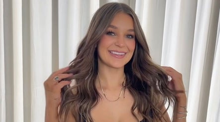 Woman with styled hair smiling at Envy Hair Company in Fort Pierce, Florida, US.