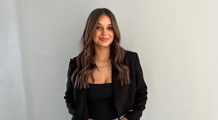 Stylish woman with long hair and black blazer at Envy Hair Company, Fort Pierce, Florida, US.