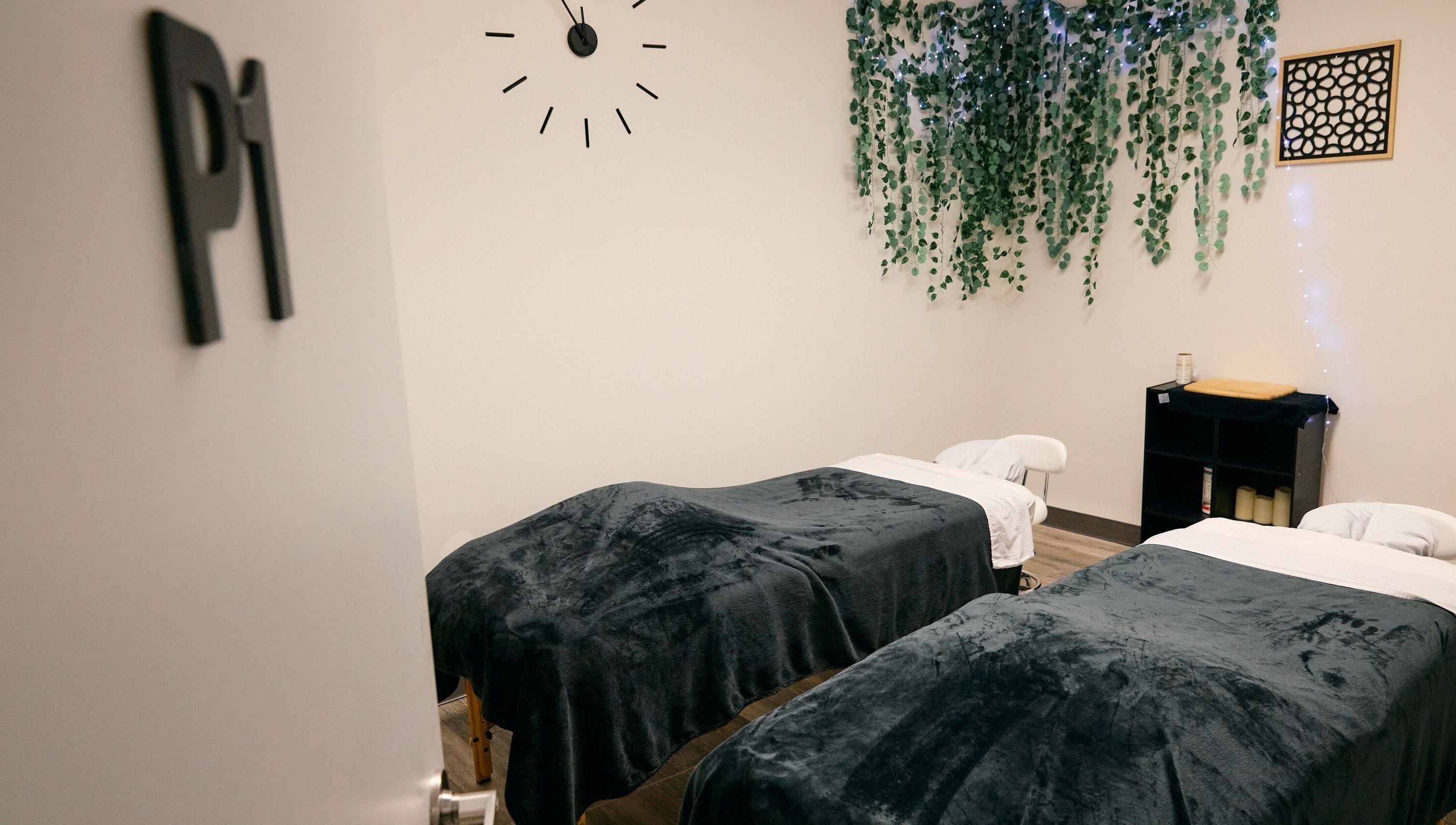 Cozy massage room at Salt and Stone Massage Therapy, Saskatoon, Saskatchewan, CA, featuring twin massage tables.